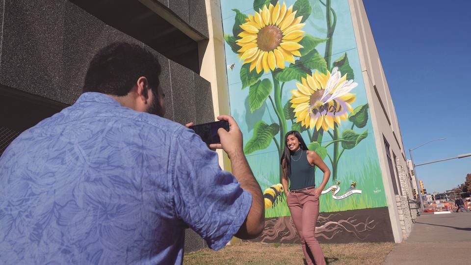 Couple taking a photo by a mural in Topeka Kansas