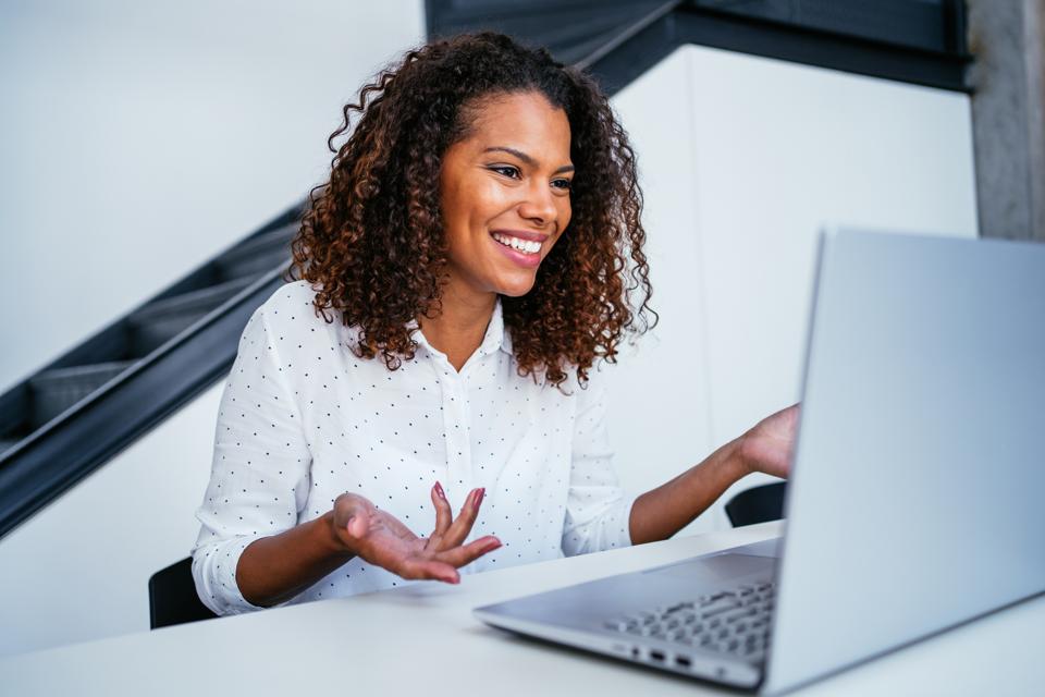 Businesswoman meets with colleagues virtually.