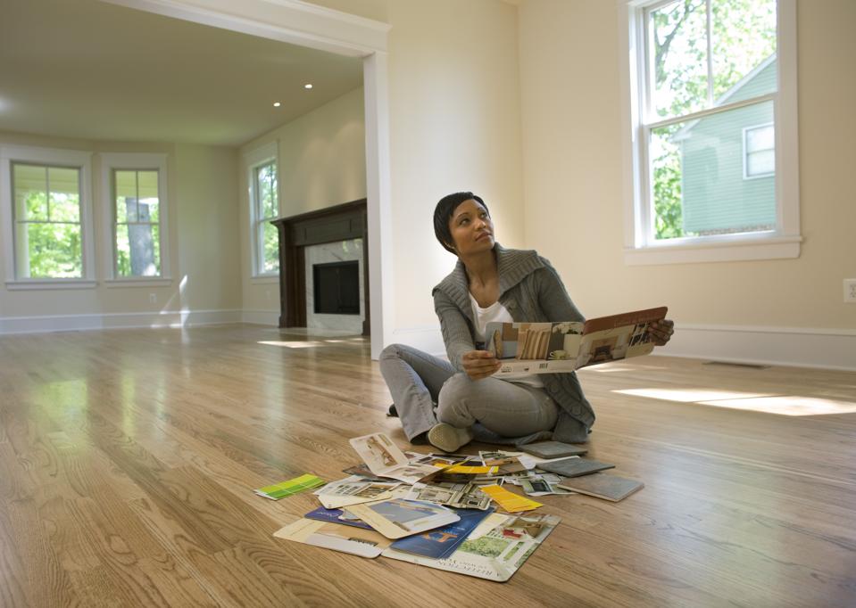 Woman looking at paint samples in empty room