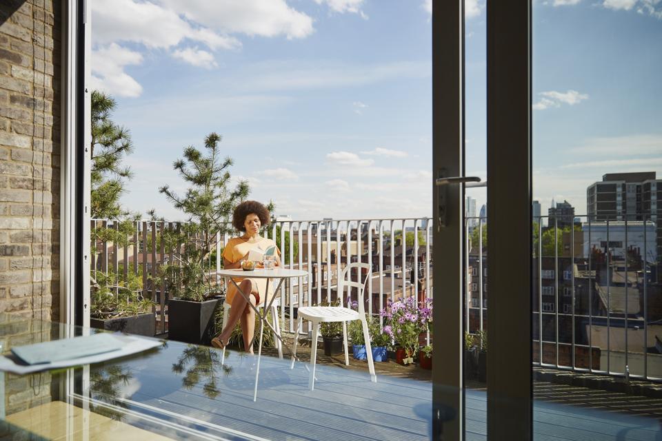 Woman sitting on balcony of apartment