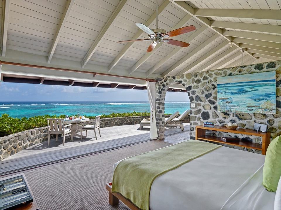 Open, whitewashed cottage interior overlooking turquoise water