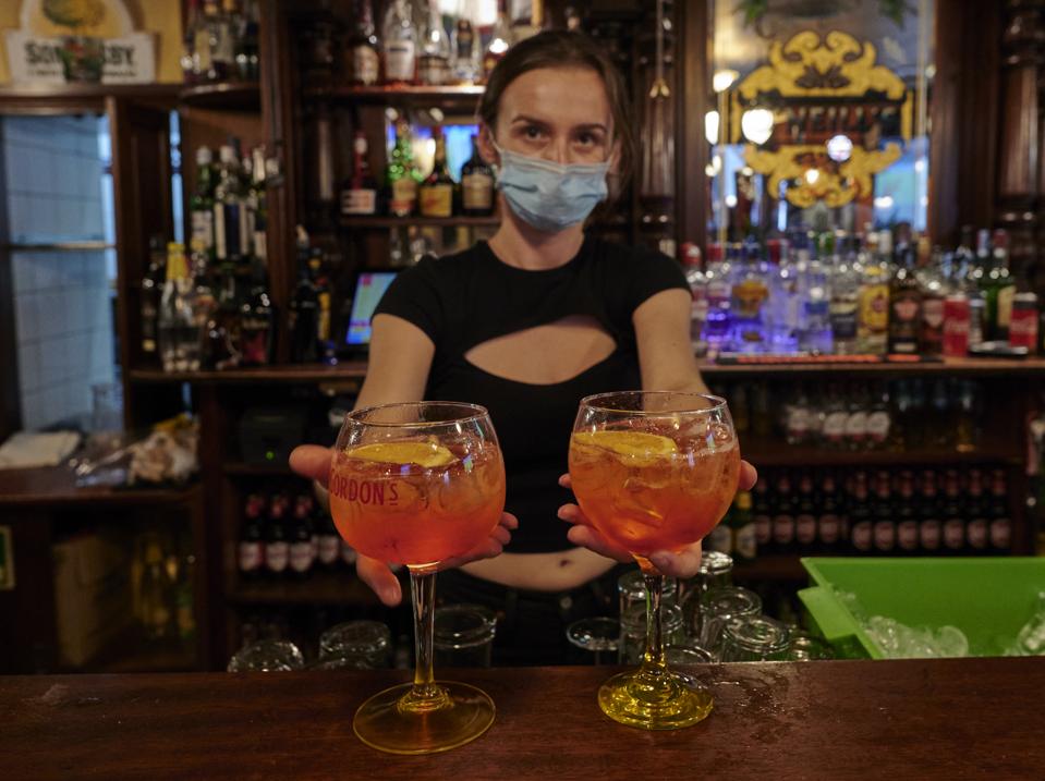 A masked staffer prepares cocktails for fans watching the UEFA Champions League Final match in Cascais, Portugal.
