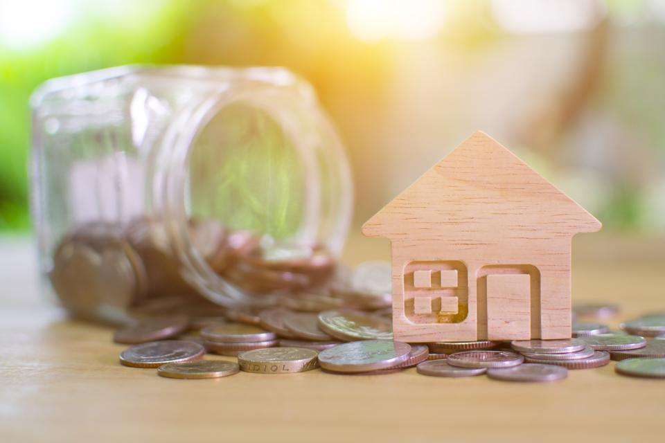House model and money on light bokeh background.Home loan for new family.Loan for real estate concept.