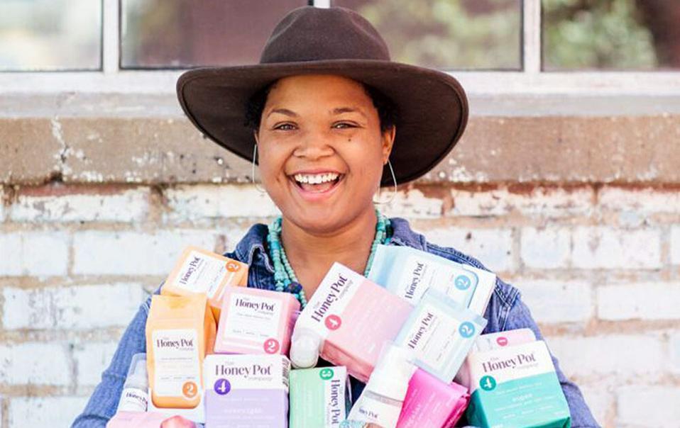 Bea Dixon smiling and holding The Honey Pot products.