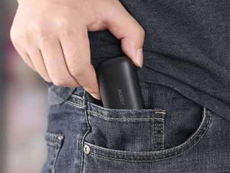 Close up of man puttin Aukey Ep-T21 in pocket