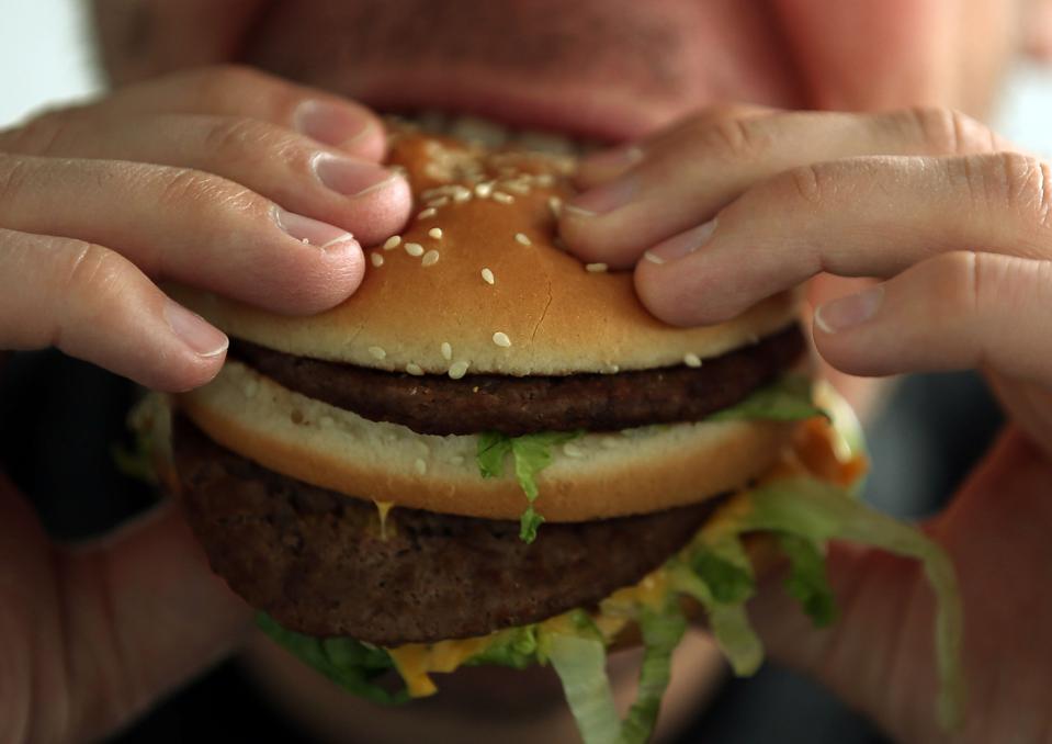 A man taking a bite of a McDonald's Big Mac.