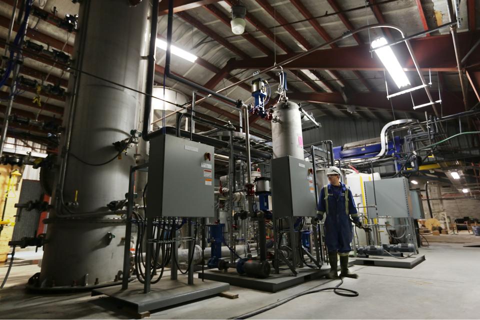 A worker standing near Carbon Engineering's ″pellet reactor″.