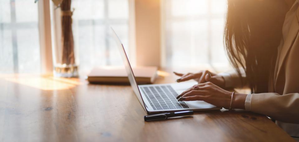 Midsection Of Woman Using Laptop On Table