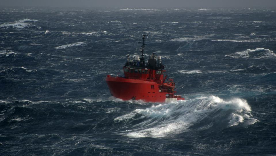 Red boat in the sea during a storm