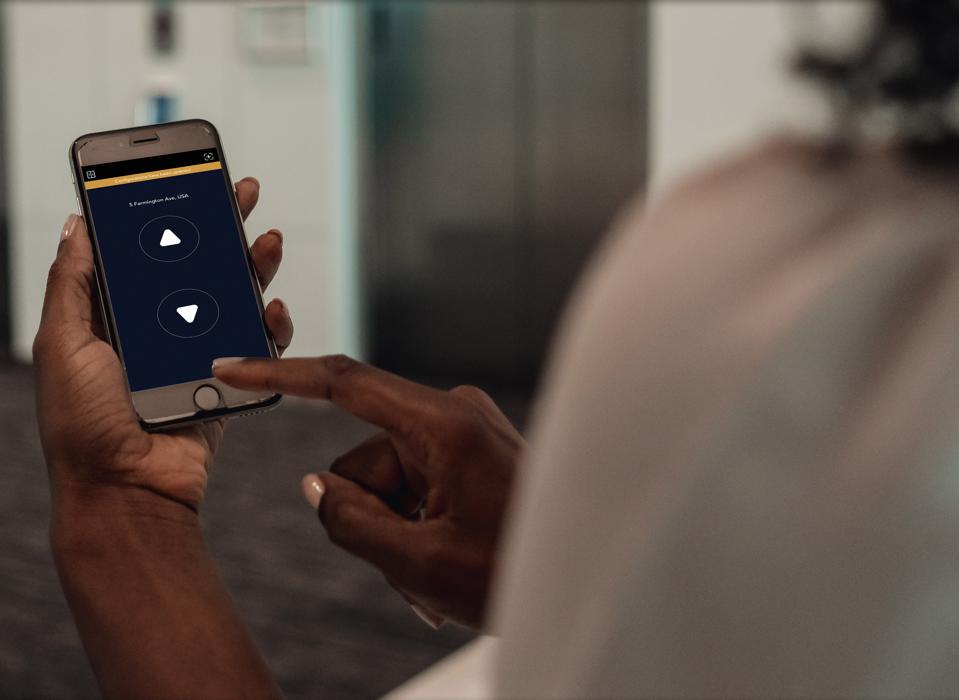 A smartphone users with the Otis eCall app displayed