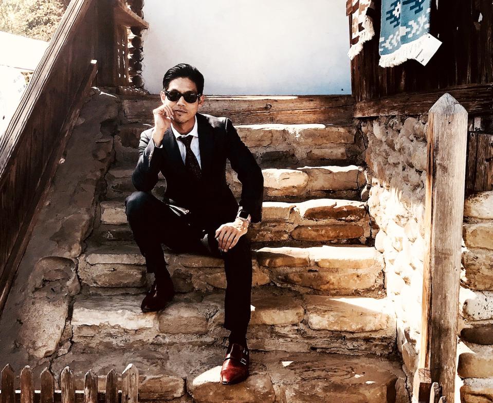 Portrait of Dr. Joseph Yi sitting on steps.