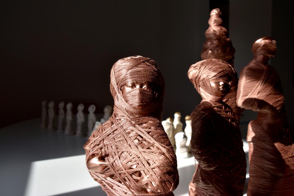 Copper figures of the human form, wrapped in copper thread.