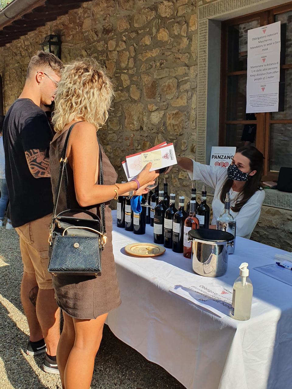 People line up at the tasting table at Vino Al Vino festival in Panzano in Chianti Italy