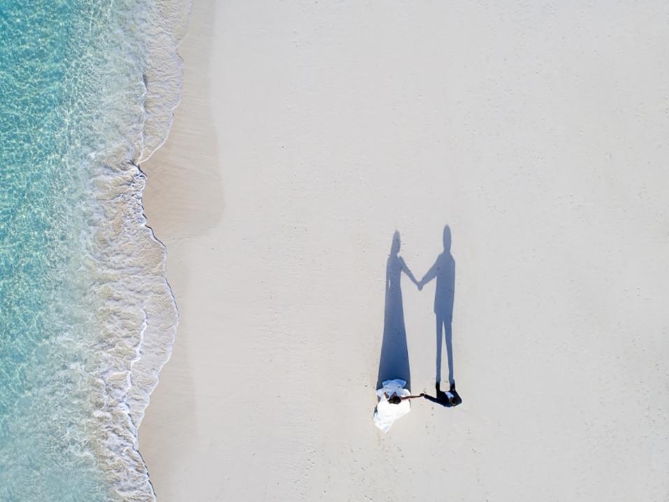 Couple de mariage marchant sur une plage, photo de drone.