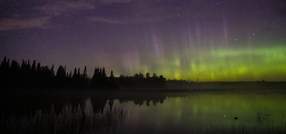 The aurora borealis on the north horizon over Wolf Lake in the Cloquet State Forest in Minnesota around midnight last September 2019.