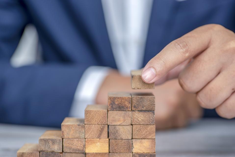 Closer up hands of businessmen,stacking wooden blocks into steps,Concept of business growth success