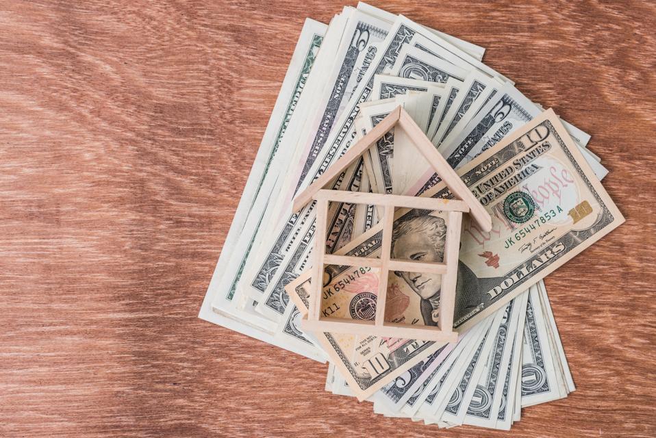 High Angle View Of Wooden Model Home On Paper Currency Over Table