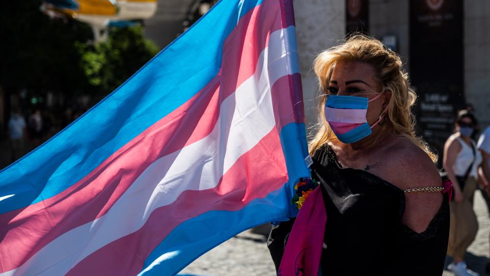 Demonstrator with the Trans flag attends a protest where...