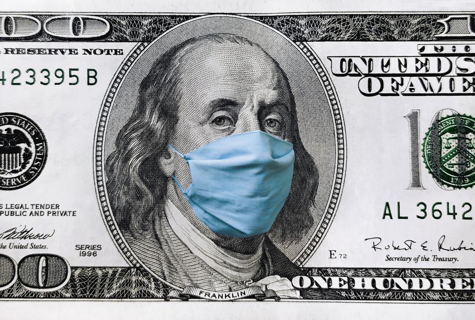 Blue medical mask on the face of Benjamin Franklin with a hundred dollar bill. The concept of the global economic crisis associated with the coronavirus quarantine COVID-19.