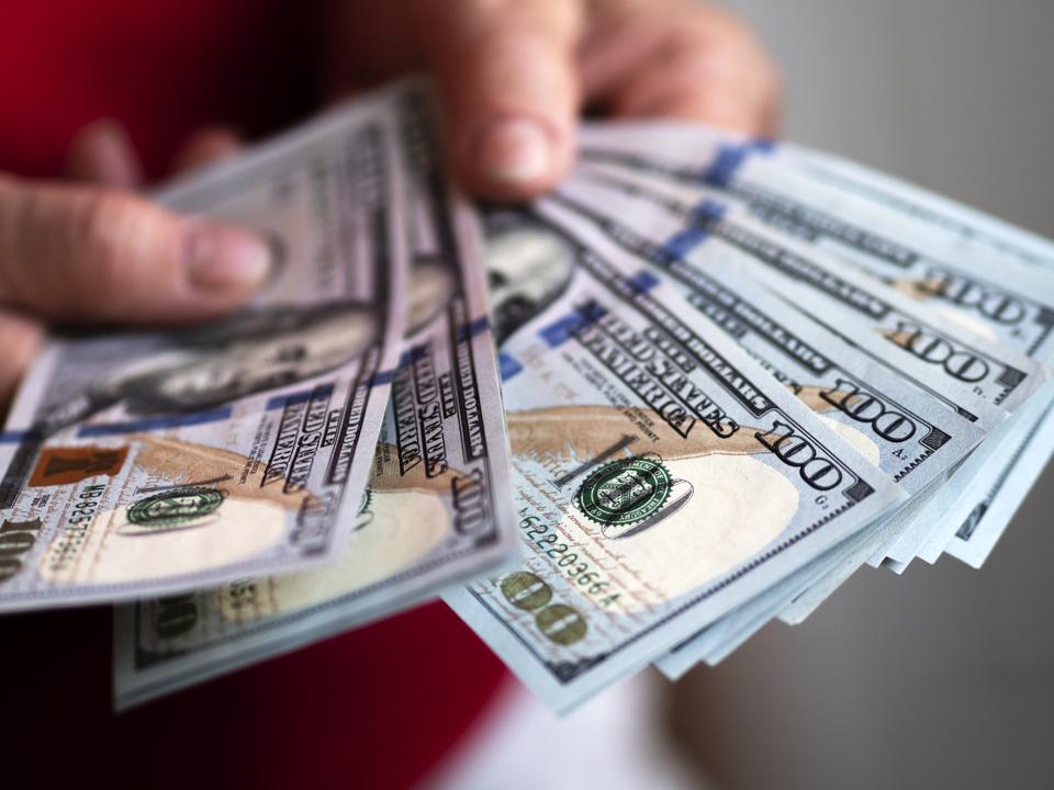 In this photo illustration one hundred US dollar banknotes...