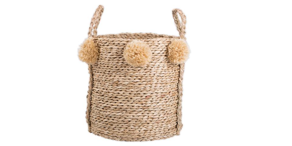 a seagrass basket with pom poms