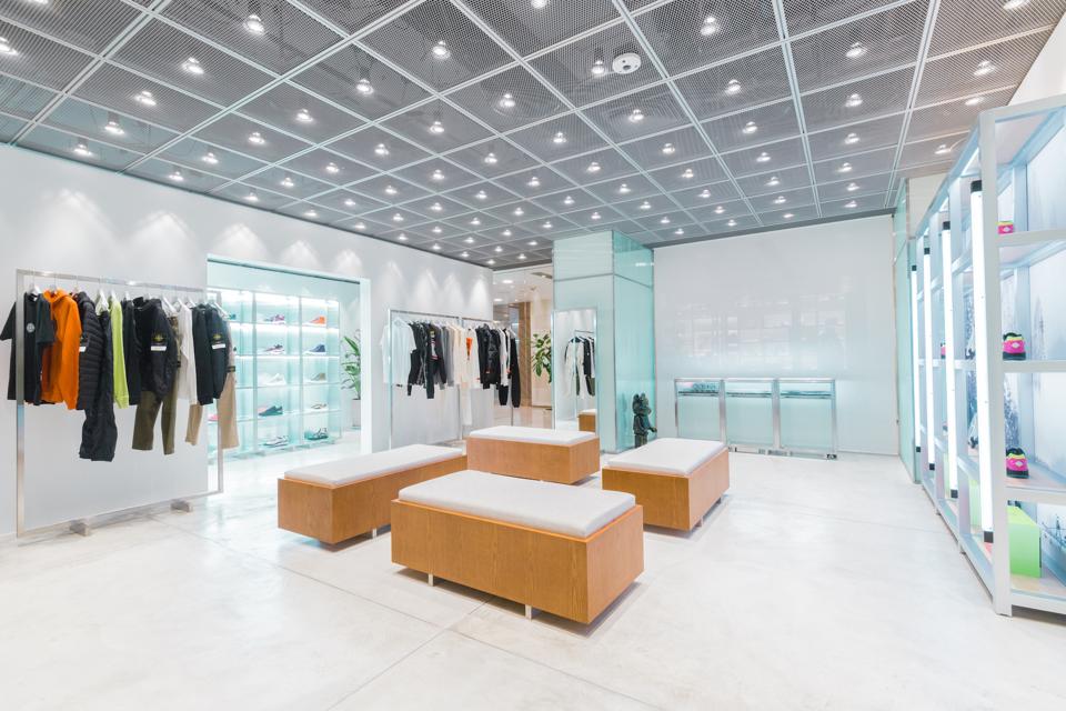 The minimalistic store design emphasizes HBX's curated merchandise and sneaker wall as the core focus of the retail experience.