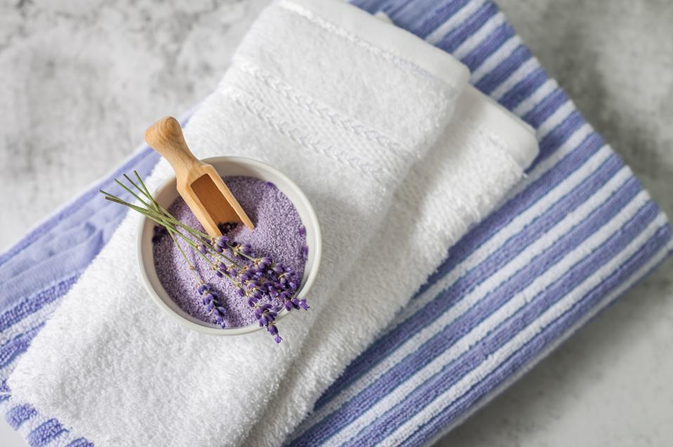 Lavender SPA. Lavender flowers and bath salt in bowl on towels background.