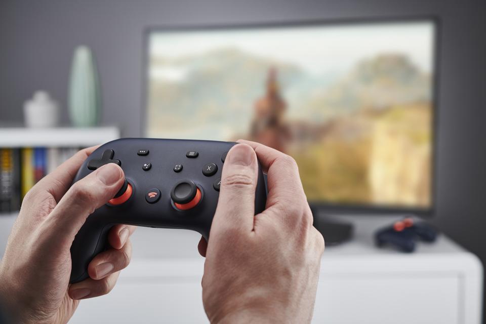 Manos sosteniendo un controlador de videojuegos Google Stadia