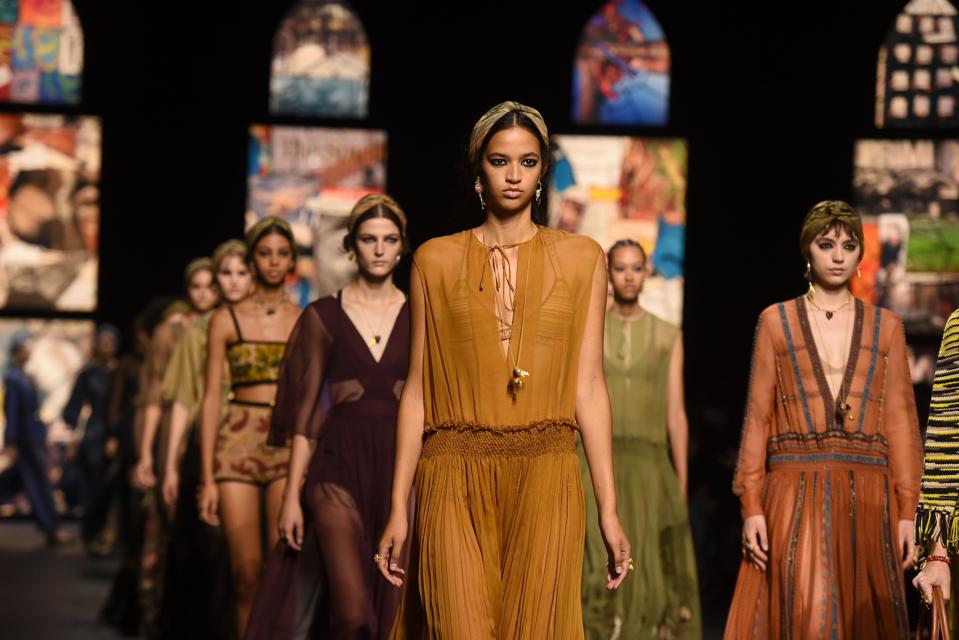 Runway models in burgundy, green, mustad and brown sheer dresses do the finale walk at the Dior Spring Summer 2021 collection.