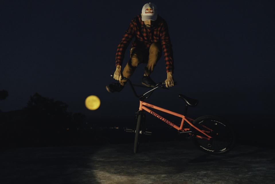 X Games Gold Medalist Terry Adams in the Arkansas Ozarks as the ″Harvest Moon″—the first full moon of fall—rises behind him. 