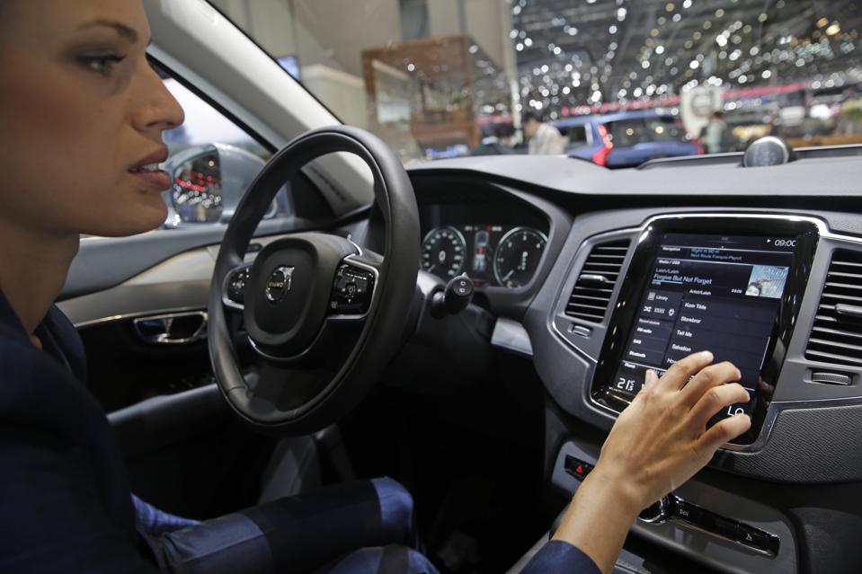 An employee demonstrates the touch-screen display of a Volvo XC-90 automobile