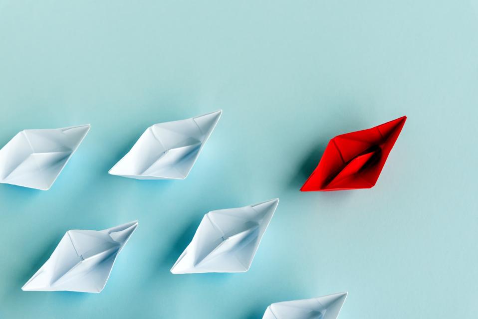 Leadership Concept - Red Paper Boat Followed by White Paper Boat on Blue Background
