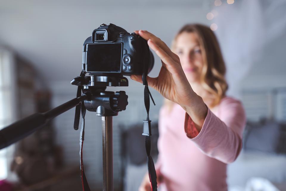 Happy female vlogger live streaming from living room