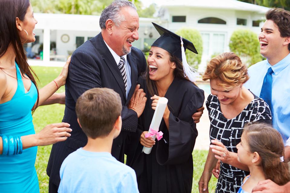 Hispanic Student And Family Celebrating Graduation