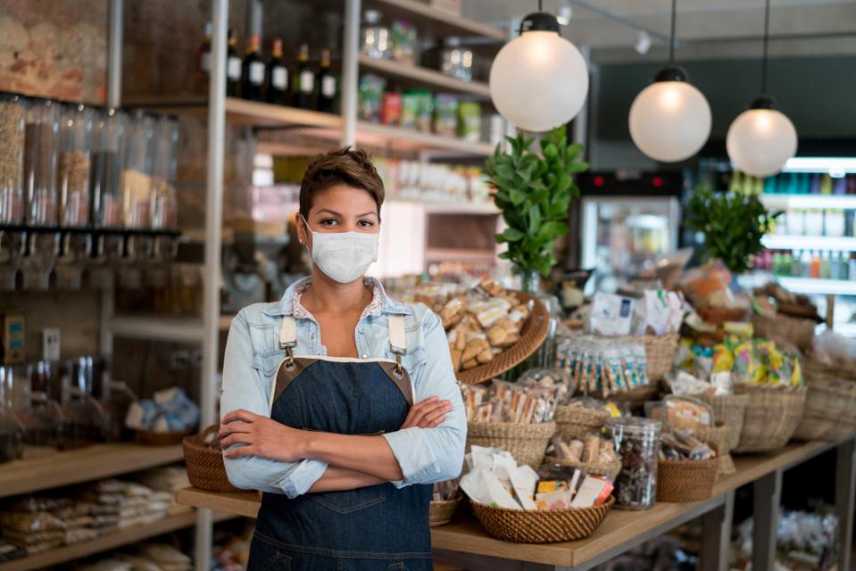 Business owner working at a grocery store wearing a facemask