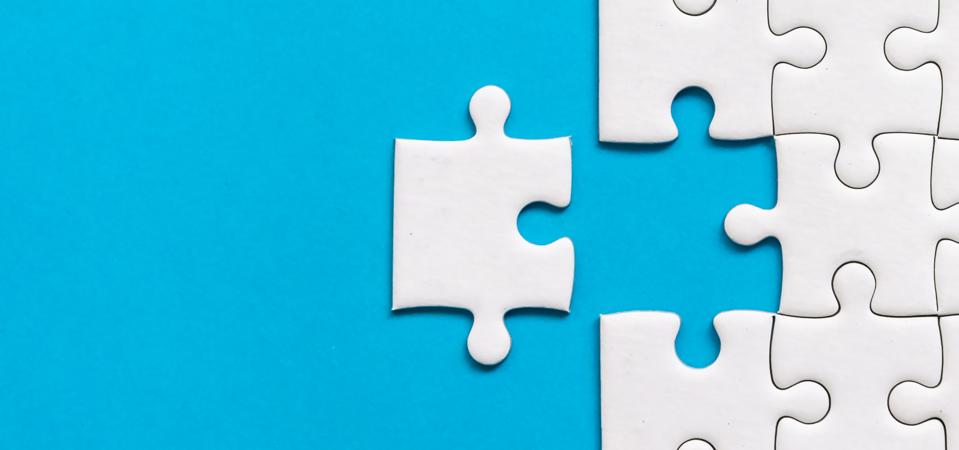White jigsaw puzzle on blue background. Team business success partnership or teamwork