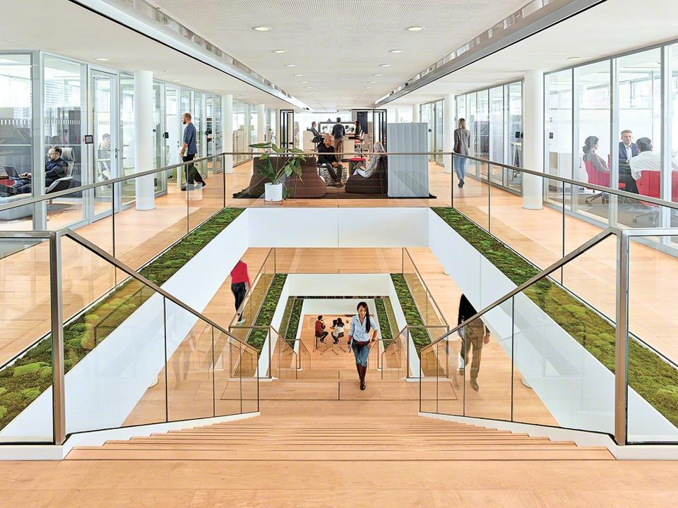 Stairwell in office with green accents and long view showing value of office for productivity and career growth.