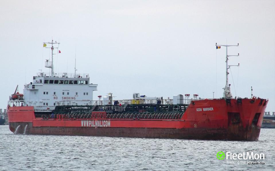 A mostly red oil tanker sailing in water.