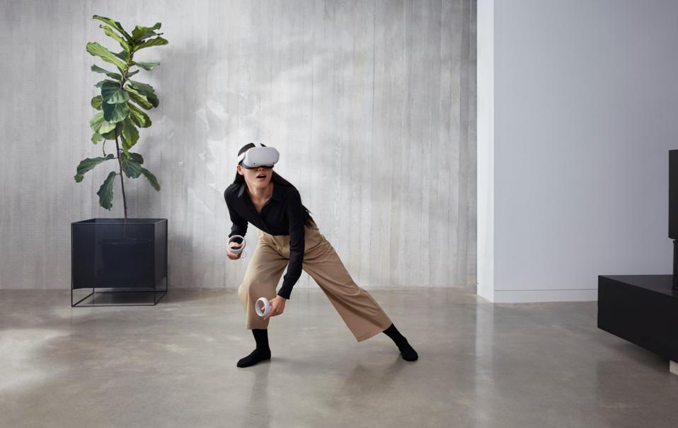 Eine Frau spielt auf der Quest 2 in einem trendig aussehenden Raum.  Sie geht in die Hocke.