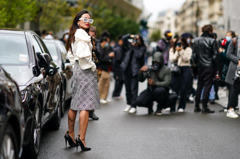 A woman posing outside a car for a street-style photograph at Paris Fashion Week Womenswear Spring Summer 2021