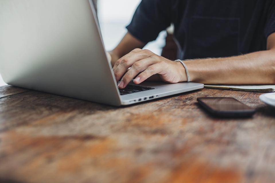 Caucasian man using laptop at table