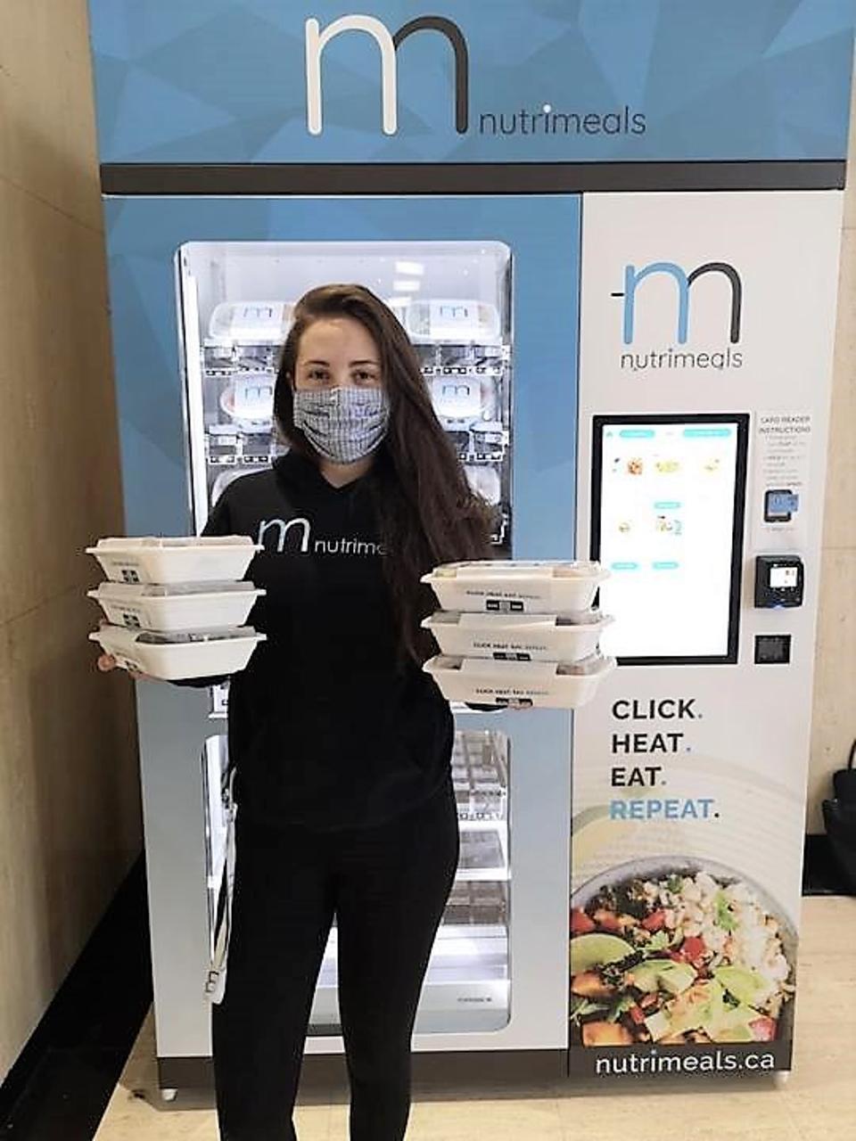 Nutrimeals vending machine with person holding ready meals.