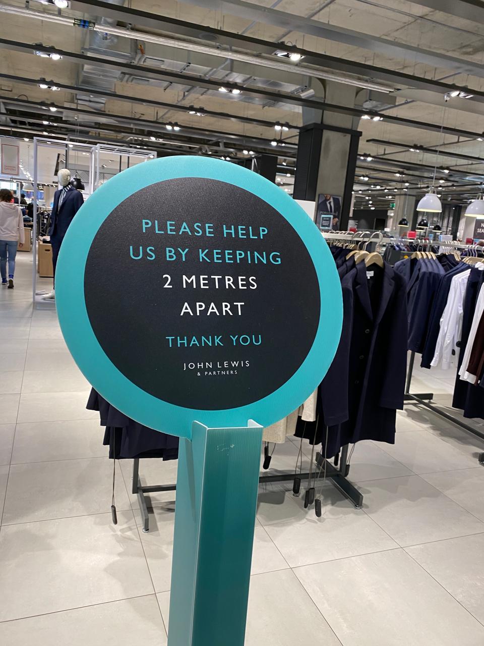 Image shows a social distancing sign in an empty John Lewis store, Leeds, UK