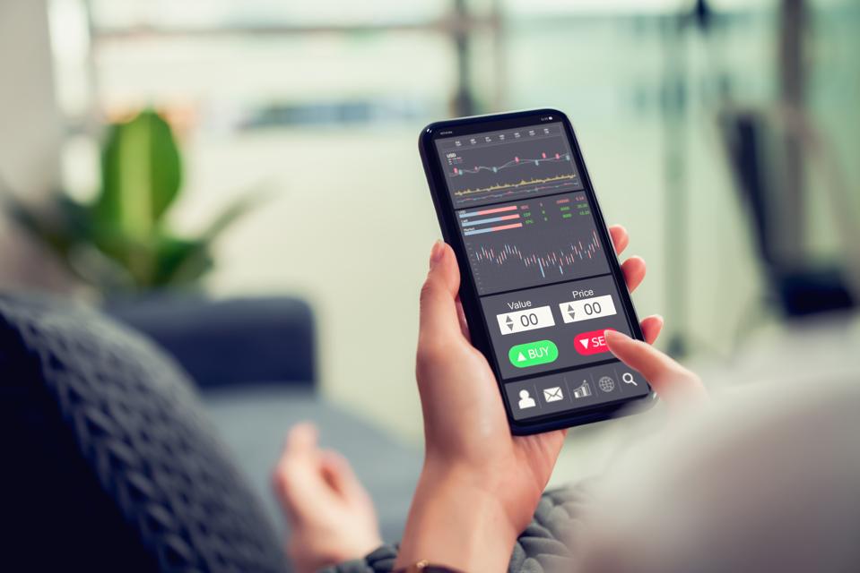 Businesswoman trader looking on smartphone with graphs analysis candle line