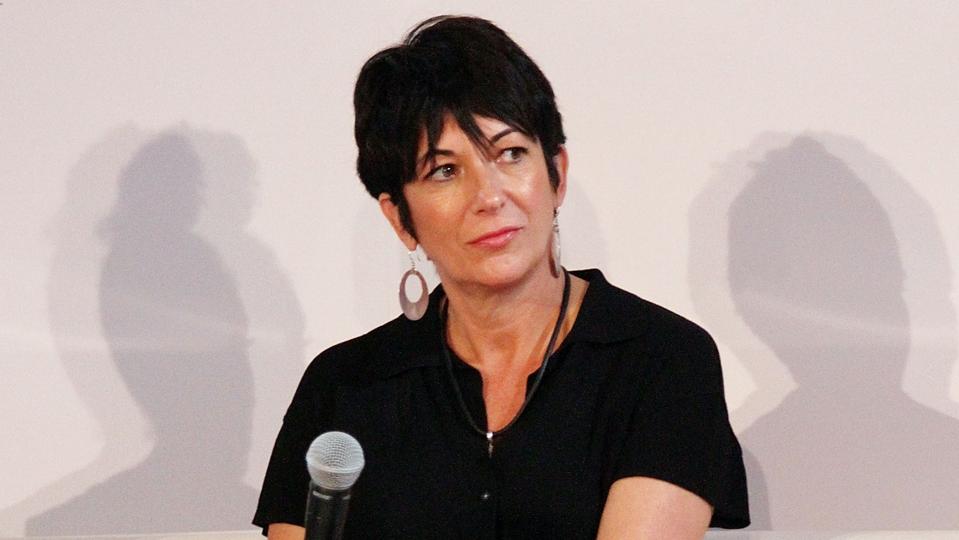 Ghislaine Maxwell wearing black holding microphone.