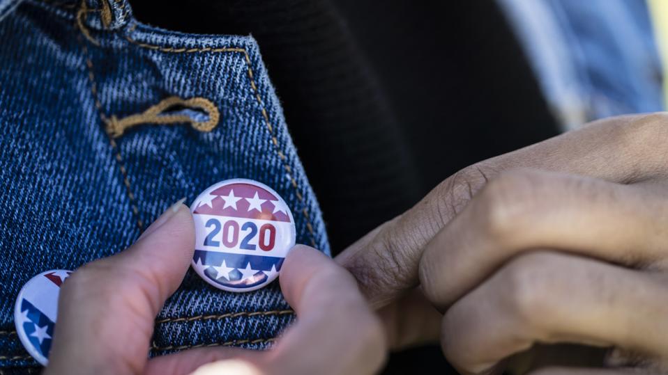 young African American woman, with election 2020 pin on her jacket