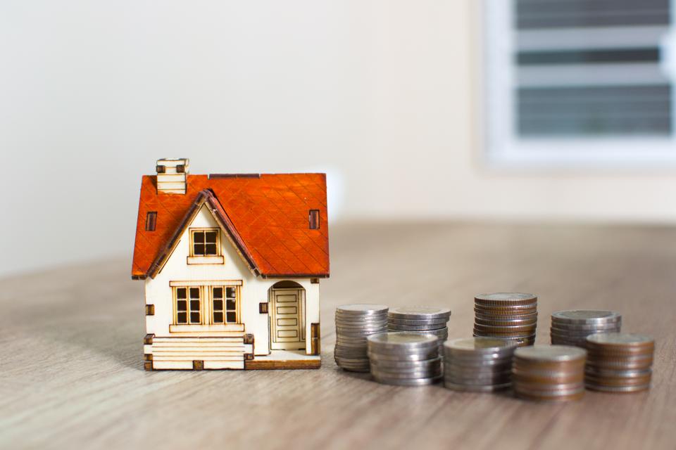 House model and coin money on table for finance and banking concept.