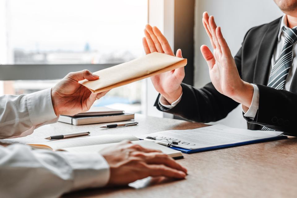 Business person refusing a document from a colleague