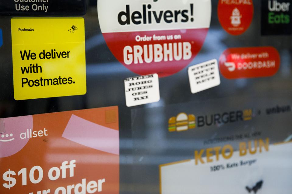 Assorted food delivery service stickers on a window