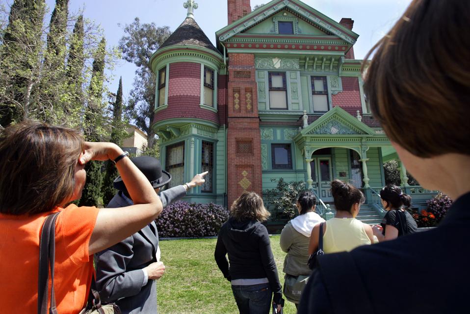 Photo of tour guide Mike Schutz points out the James and Bessie Hale house as part of the postcard